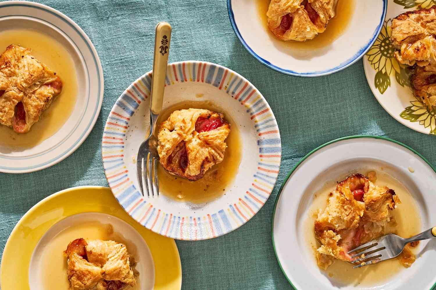 Peach dumplings on colorful plates with forks