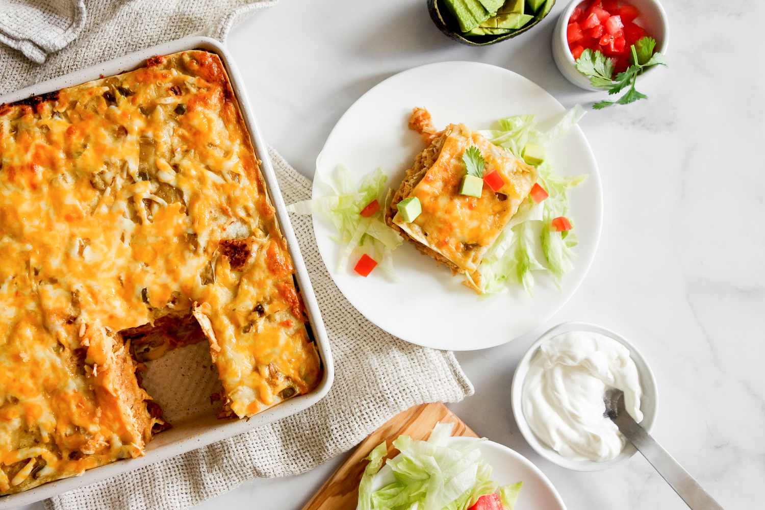 Sliced burrito casserole on plate with toppings.