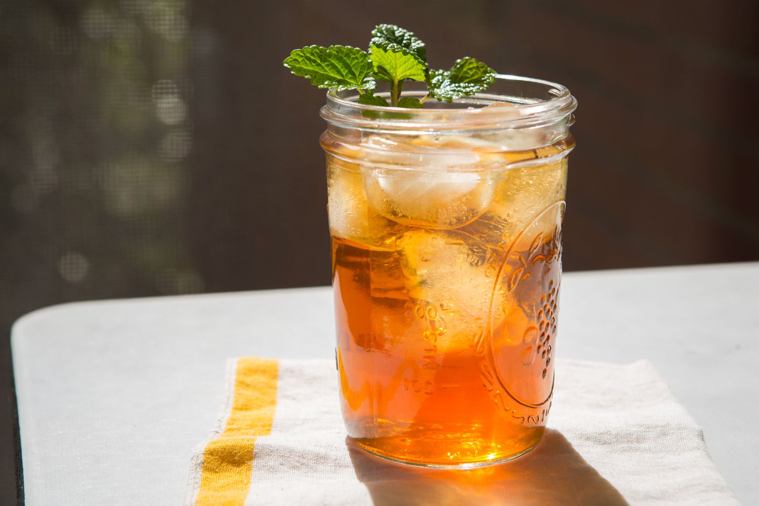 Iced tea in a mason jar with a sprig of fresh mint