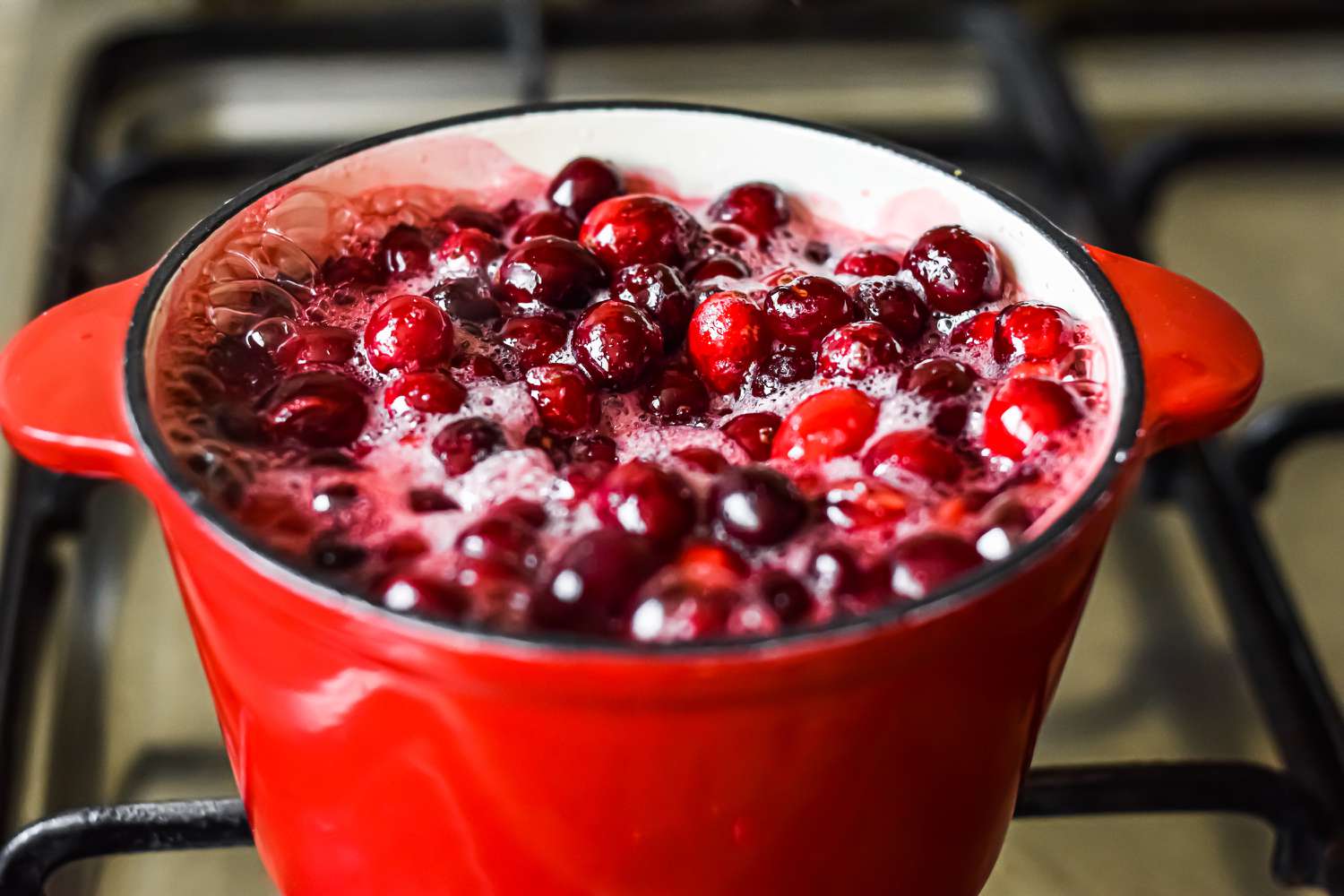 Fresh cranberries boiling in a Dutch oven 