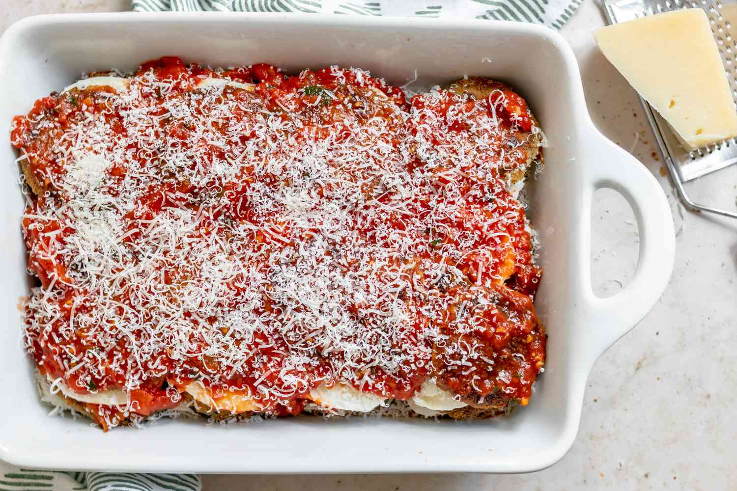 Eggplant parmesan in a casserole dish ready for the oven.