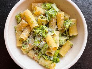 Overhead shot of a bowl of rigatoni pasta with broccoli and parmesan cheese
