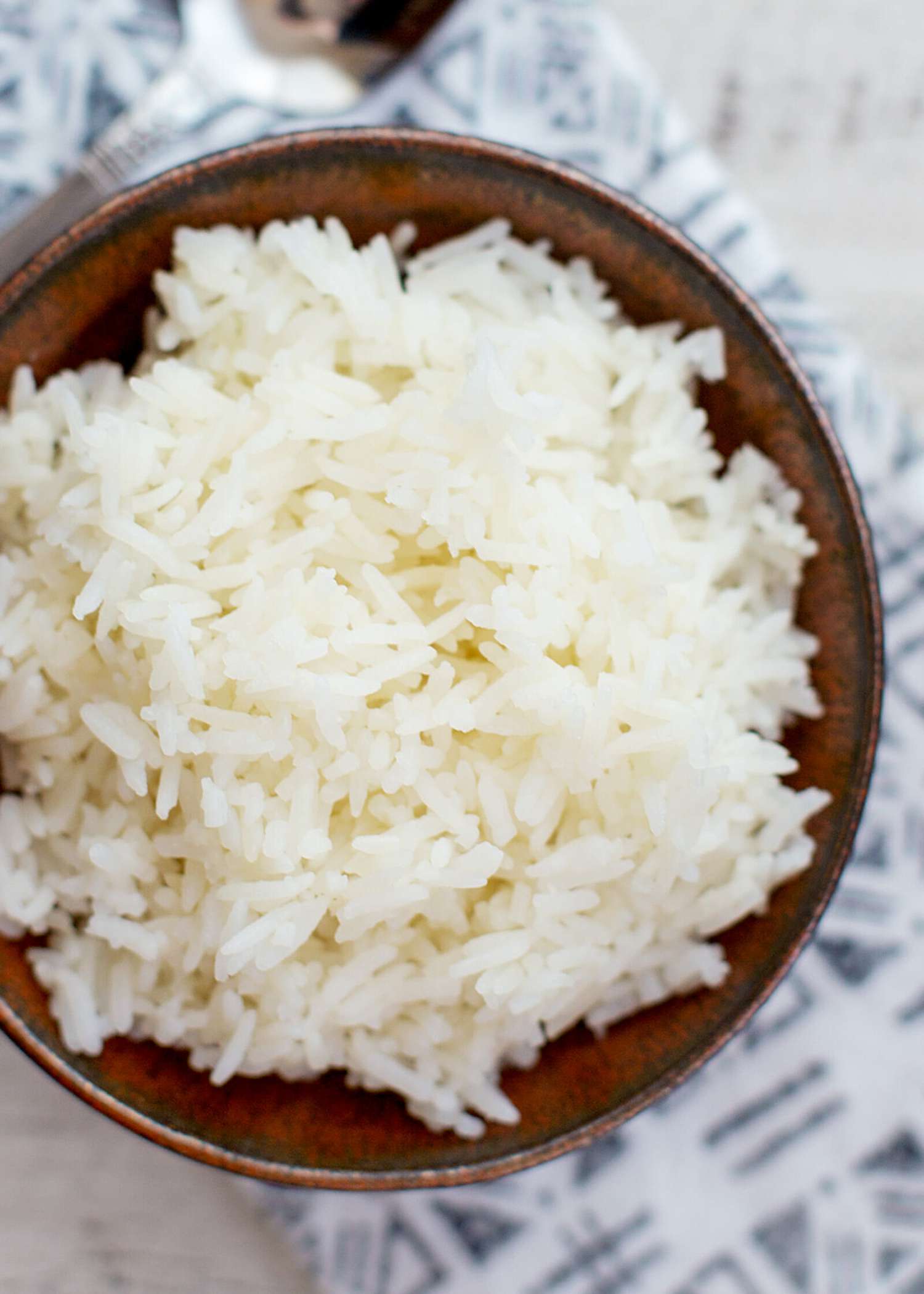 Overhead of white rice in a brown bowl