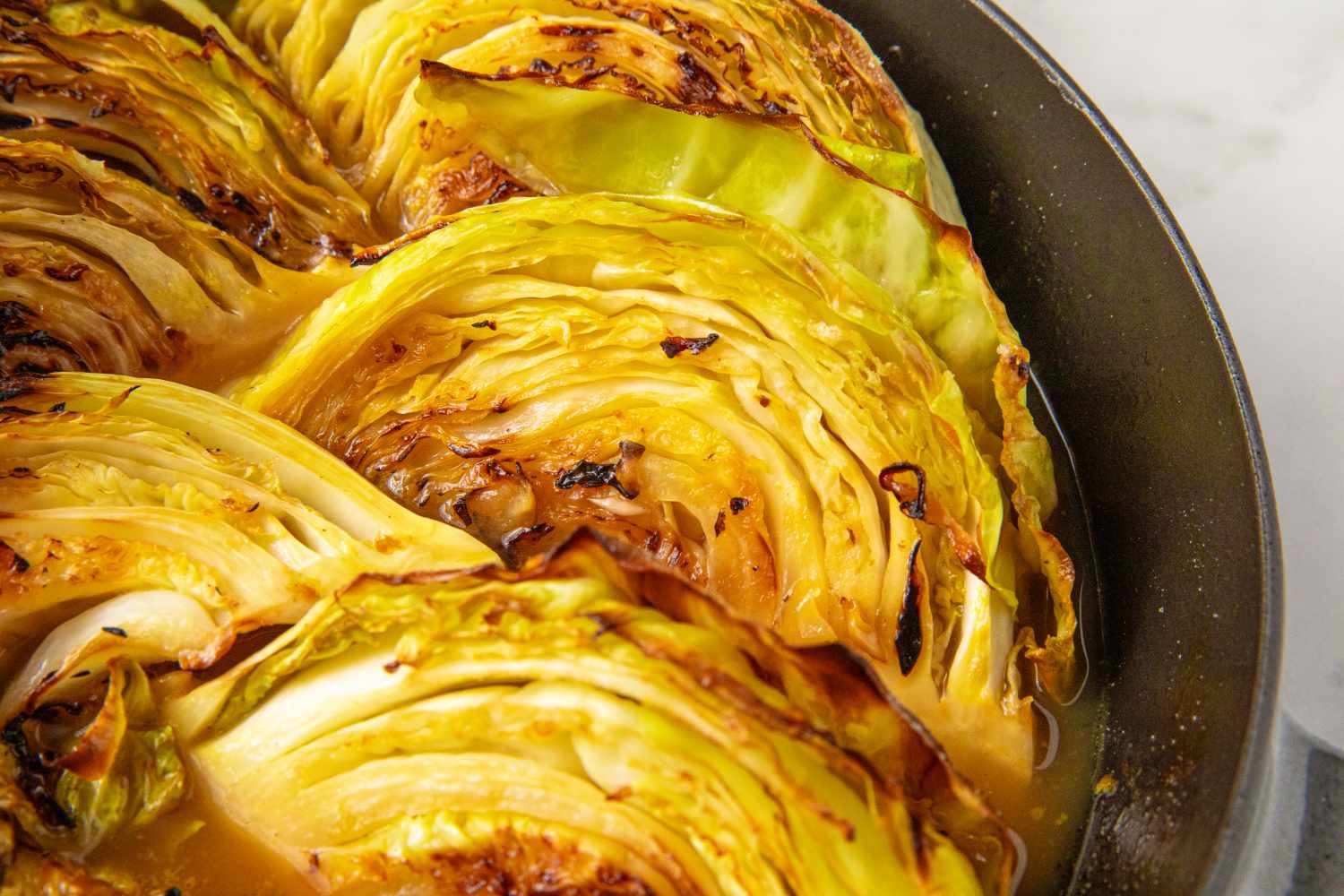 Cooked cabbage slices in a pan with a sweet and sour glaze