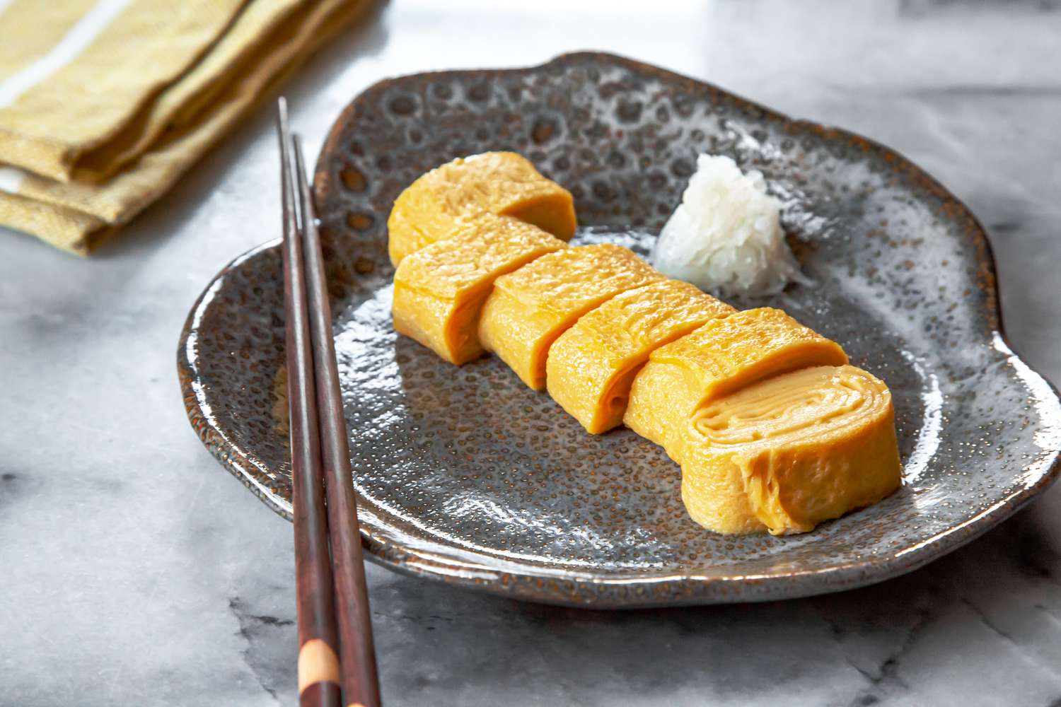 Tamagoyaki Cut into Pieces on Plate with Chopsticks