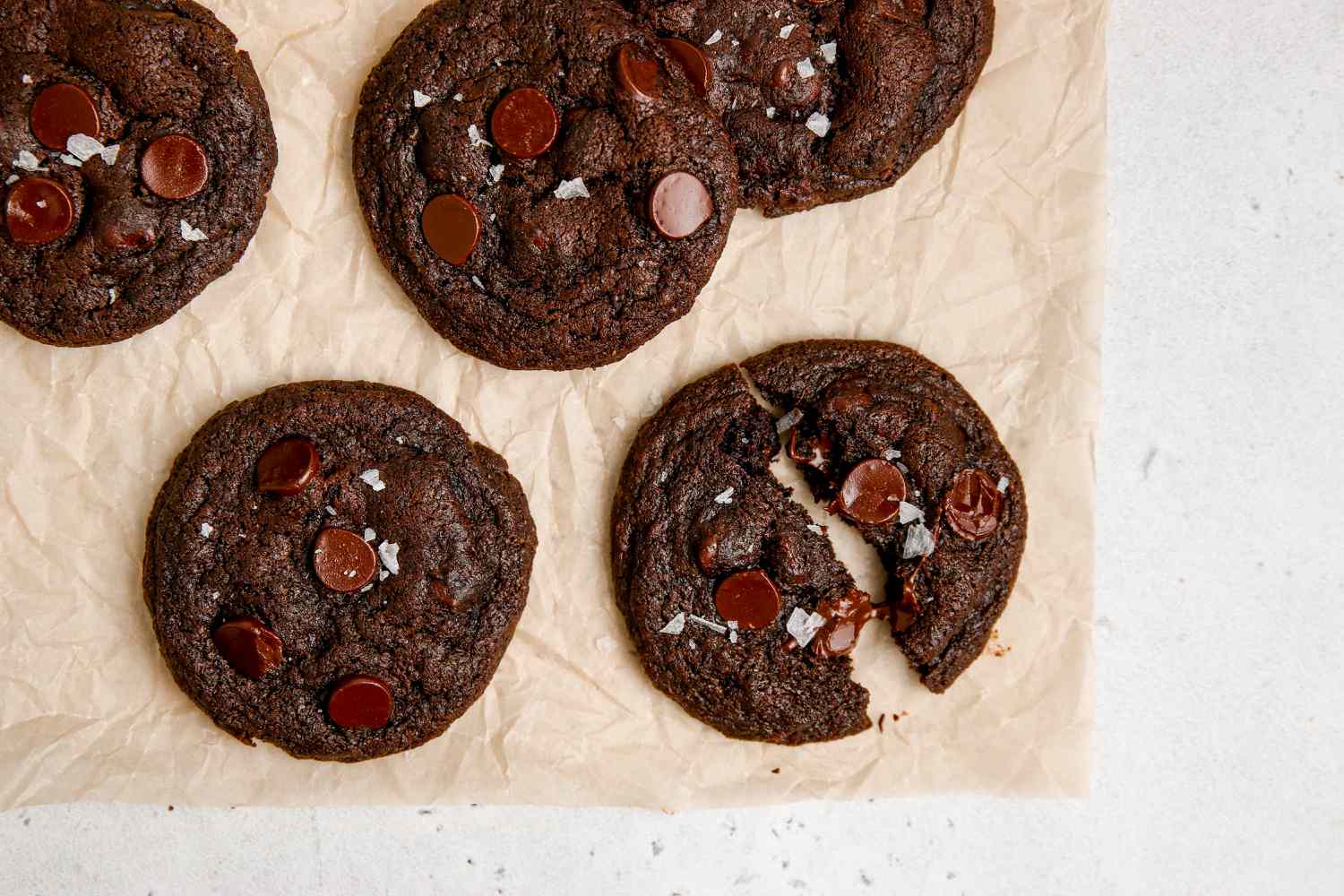 A baking sheet with chocolate chip chocolate cookies on it