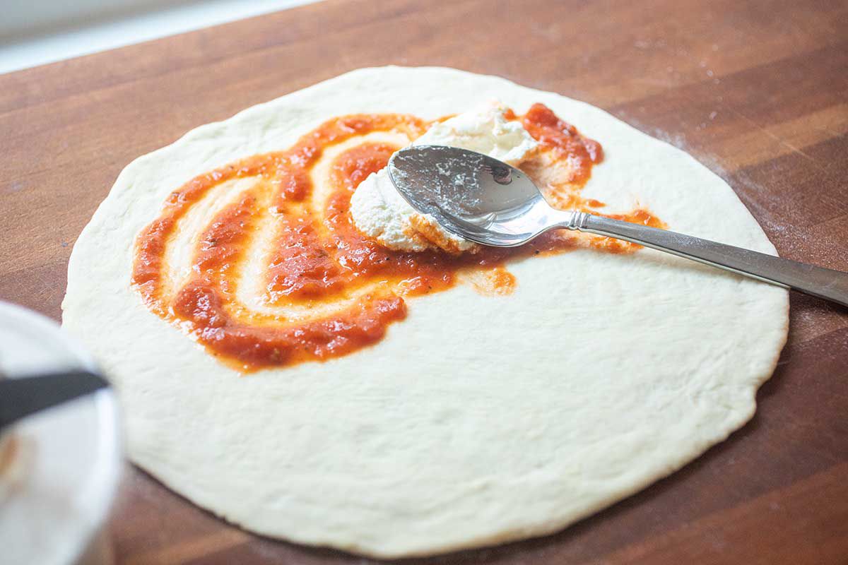 Pizza Dough spread with sauce to make a Pepperoni Calzone