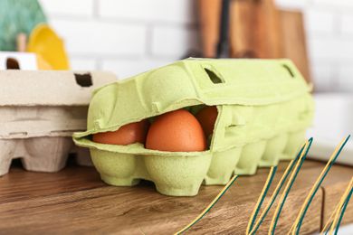Carton of eggs on the counter and some blue and yellow lines in the lower right corner of the photo