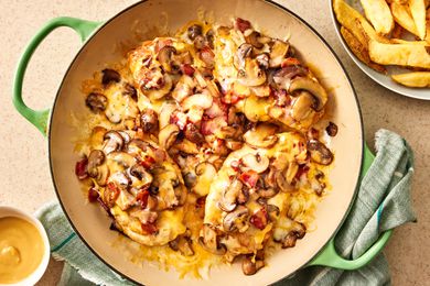 Overhead view of Alice Springs chicken in a braiser next to a plate of steak fries and bowl of honey mustard