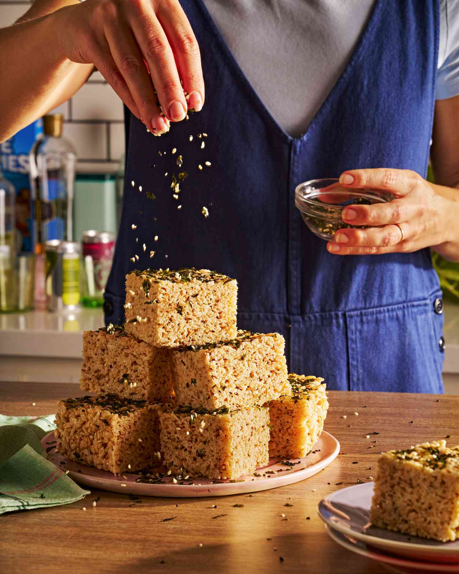 Sprinkling furikake over a platter of toasted pinipig marshmallow treats