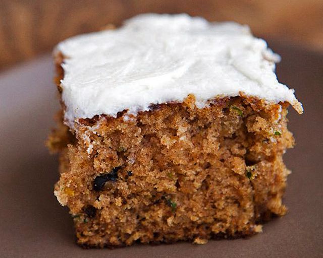 A plated square slice of zucchini cake with cream cheese frosting