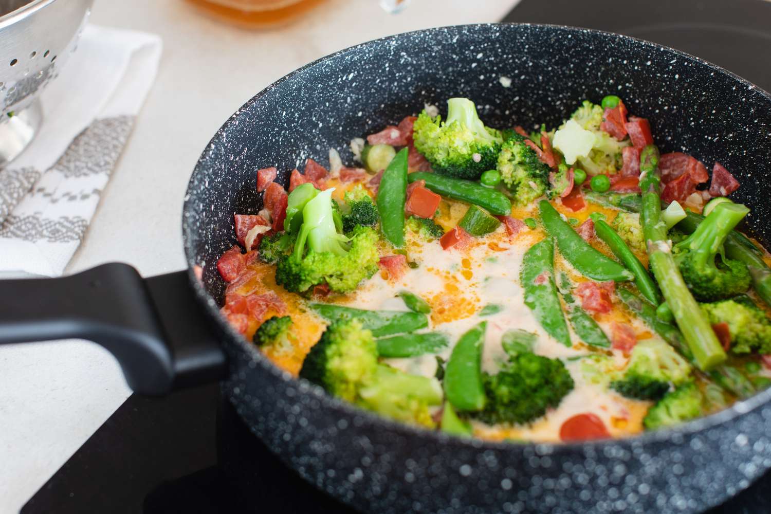 A skillet with the vegetables and primavera sauce inside.