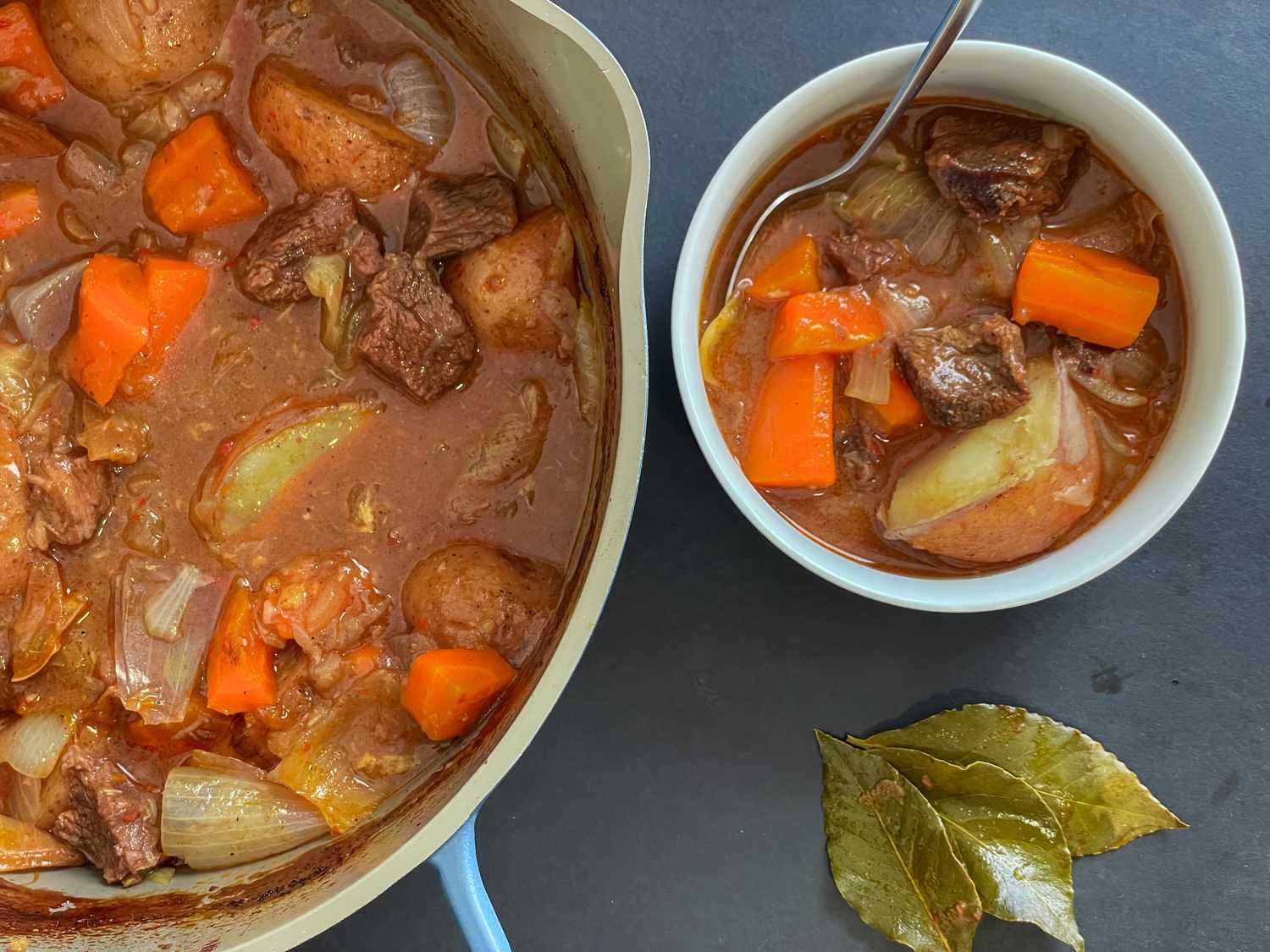 A pot of Martha's beef stew, with a small bowl of the stew next to it