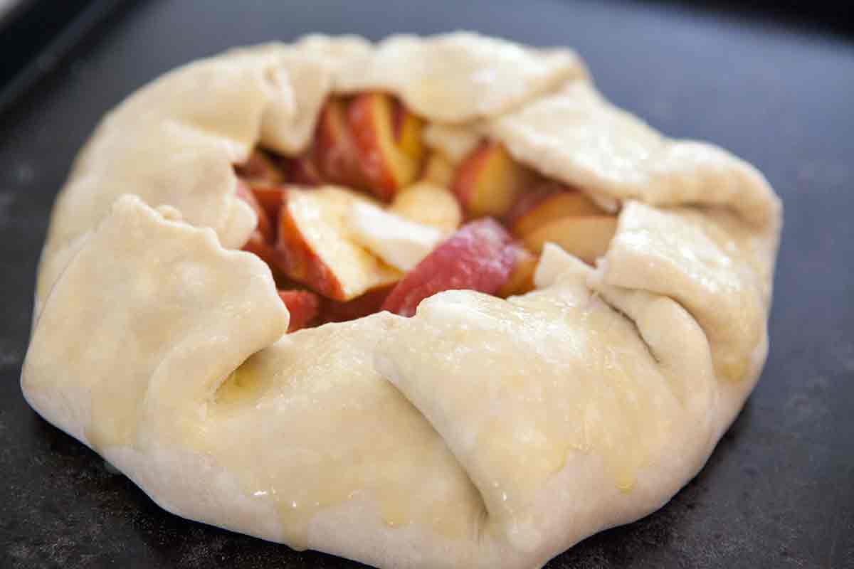 brush uncooked peach galette crust with egg wash