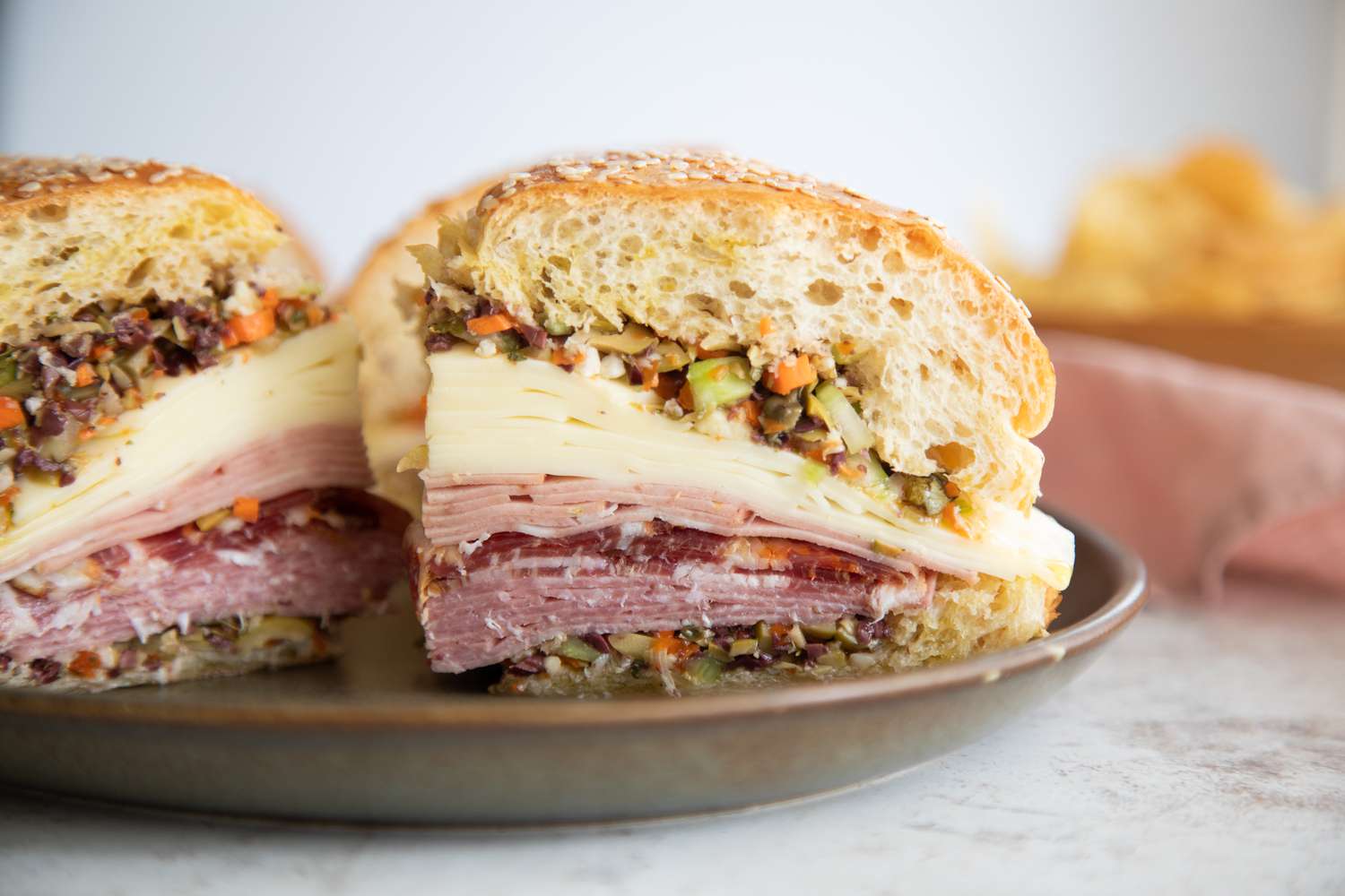 A Plate with Quarters of a Classic Muffuletta Sandwich Made with Cold Cuts, Cheese, and Olives