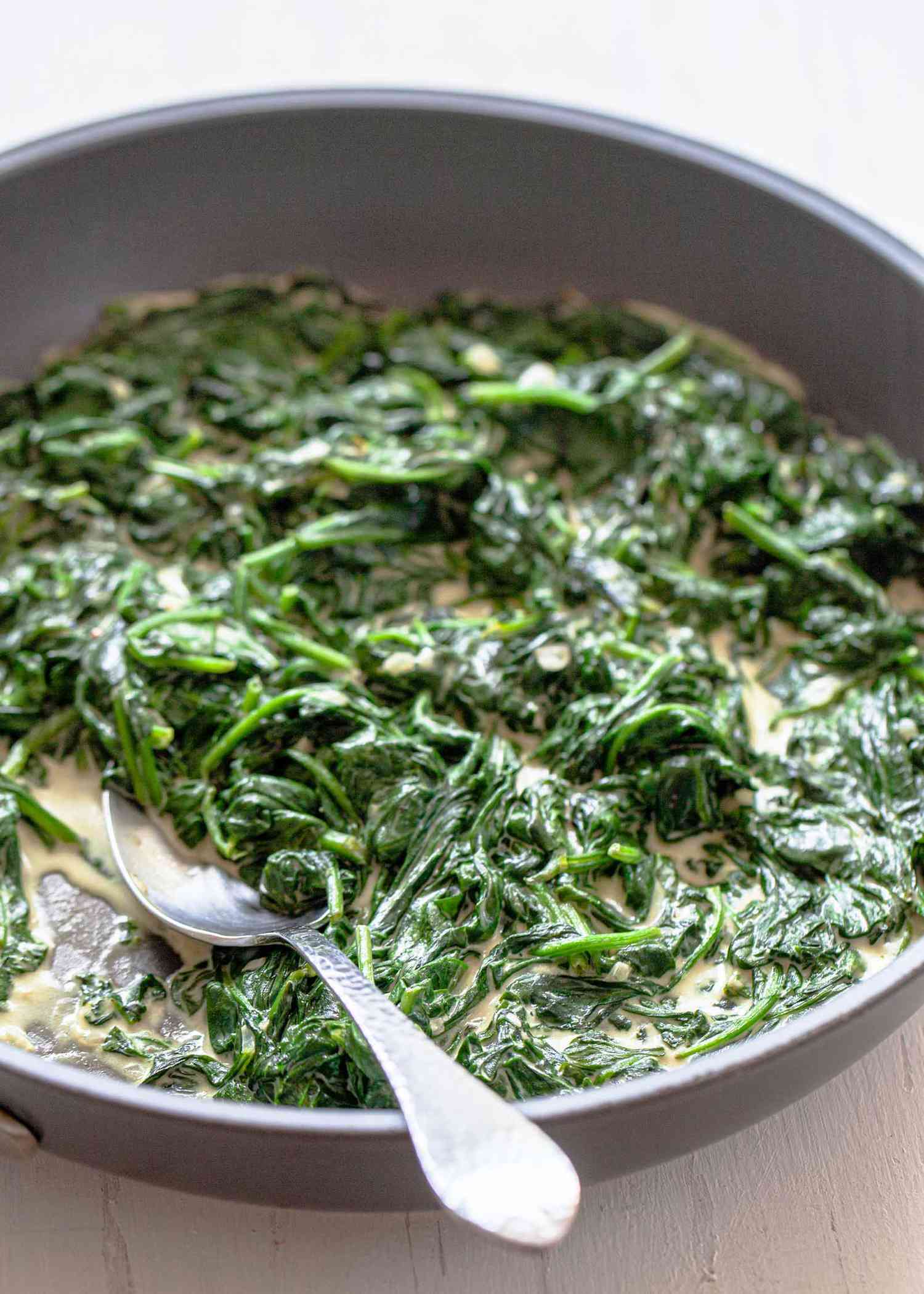 Homemade Creamed Spinach and a serving spoon.