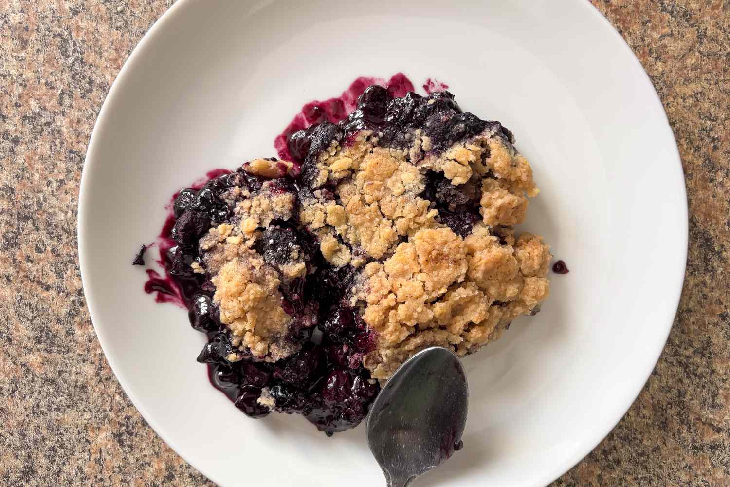 Overhead shot of Martha Stewart's blueberry crisp on a white plate