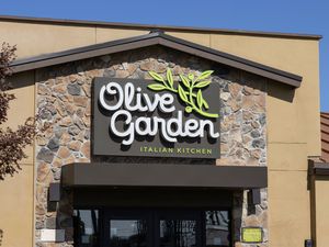 The front of an Olive Garden restaurant showing its sign and entrance