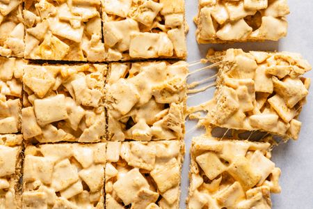 Cereal and marshmallow dessert bars cut into squares one slightly pulled away