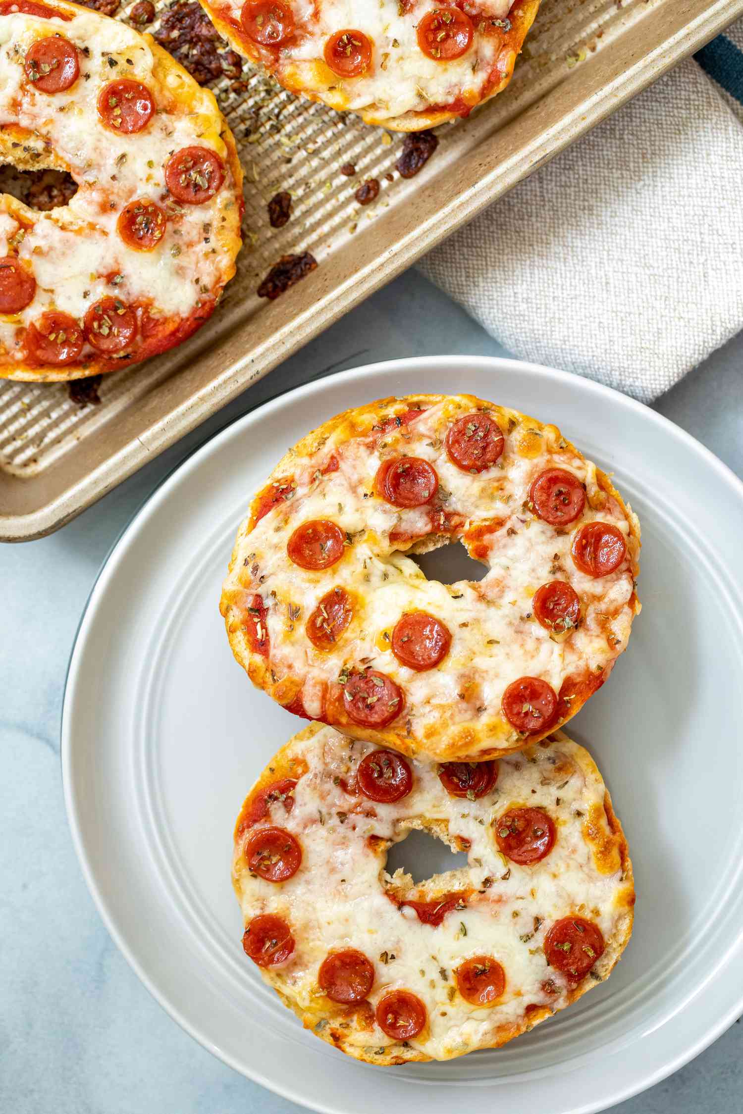 Pizza bagel on a grey plate.