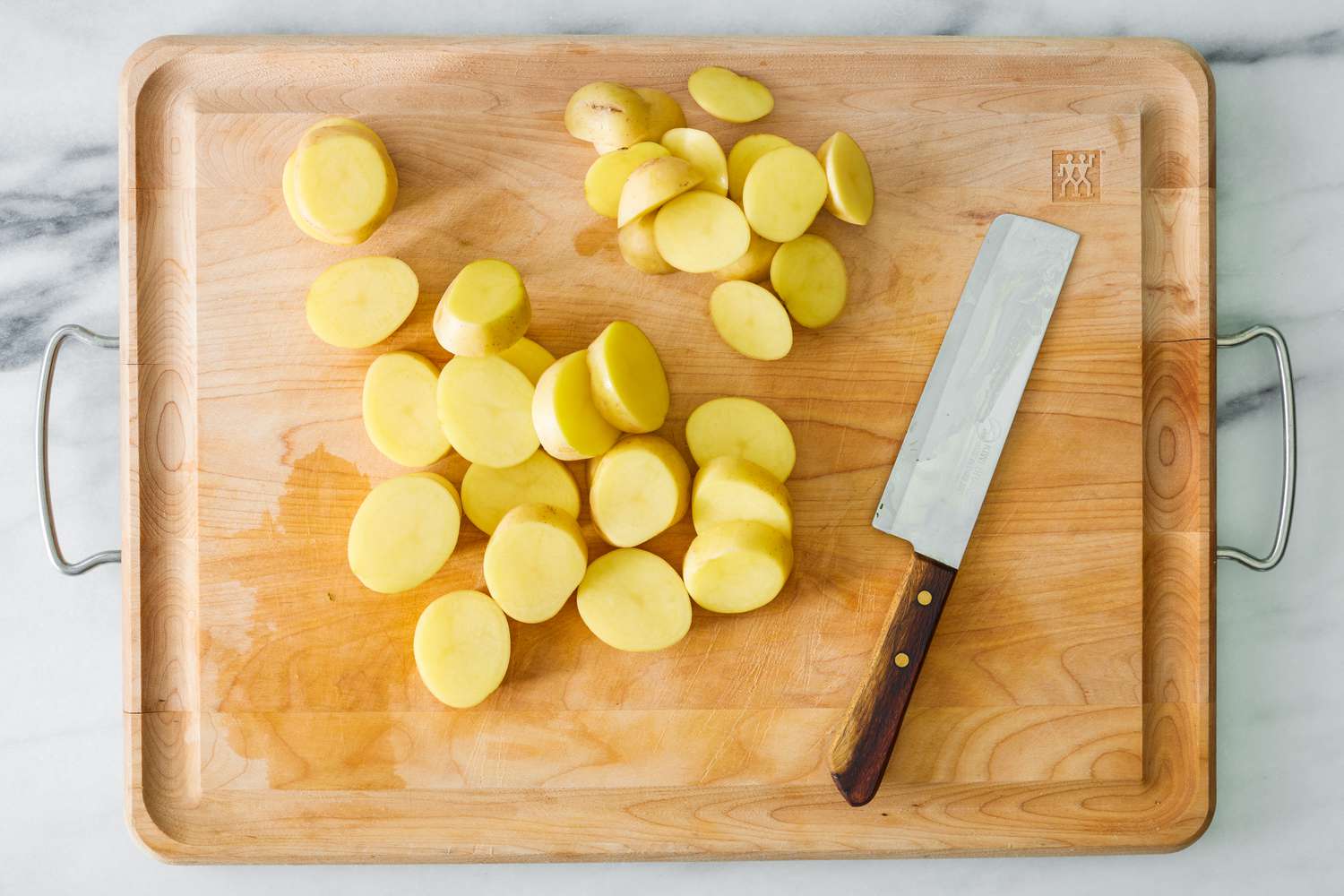 Sliced potatoes on a wooden cutting board for the miso melting potatoes recipe