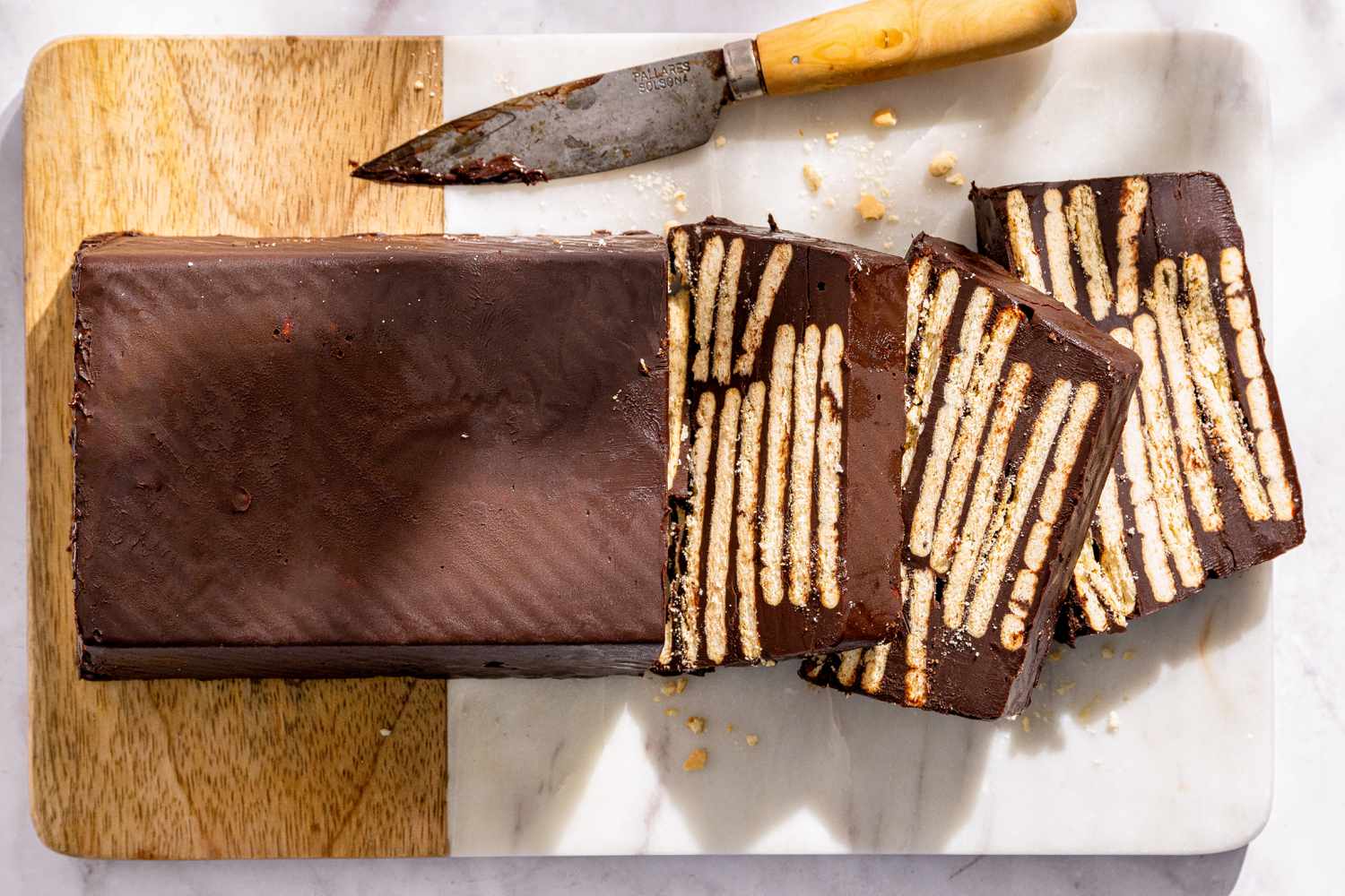 German hedgehog slice dessert, layered chocolate and biscuit slices on a cutting board with a knife