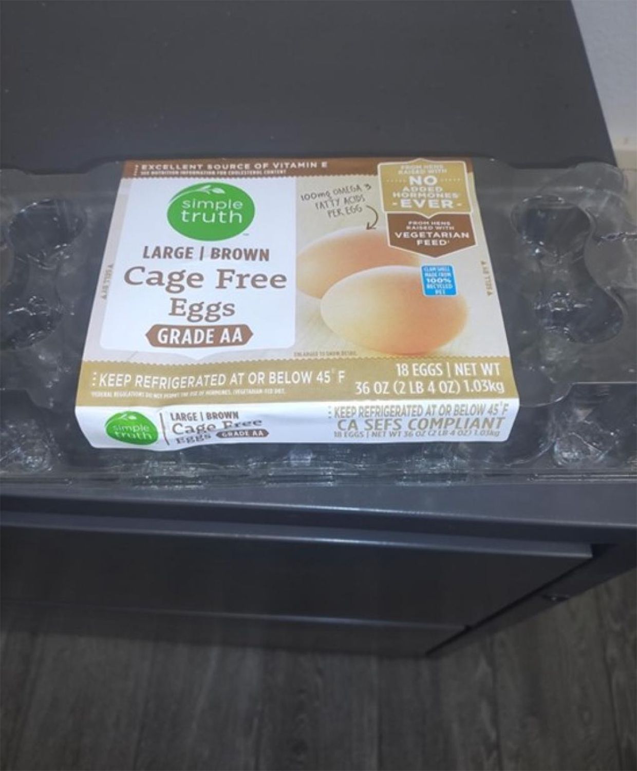 A carton of cage-free eggs labeled 'Simple Truth Large Brown Eggs' placed on a countertop, displaying packaging details