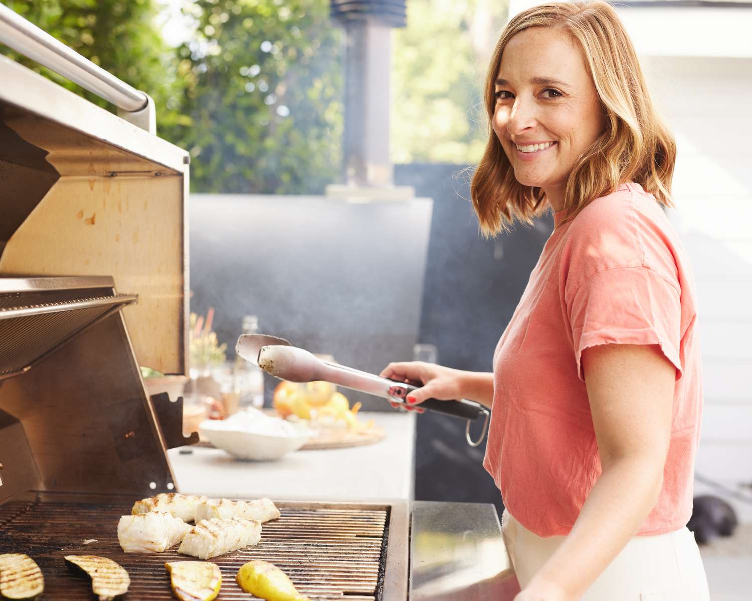 Gaby Dalkin Holding Tongs at an Outdoor Grill, Grilling Fish and Squash 