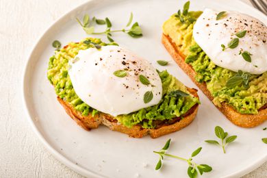 Avocado toast with a perfect poached egg on top with salt and pepper
