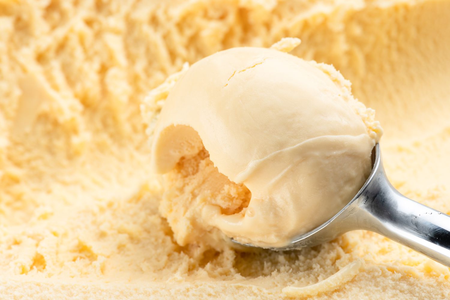 ice cream in an ice cream scoop over more ice cream 