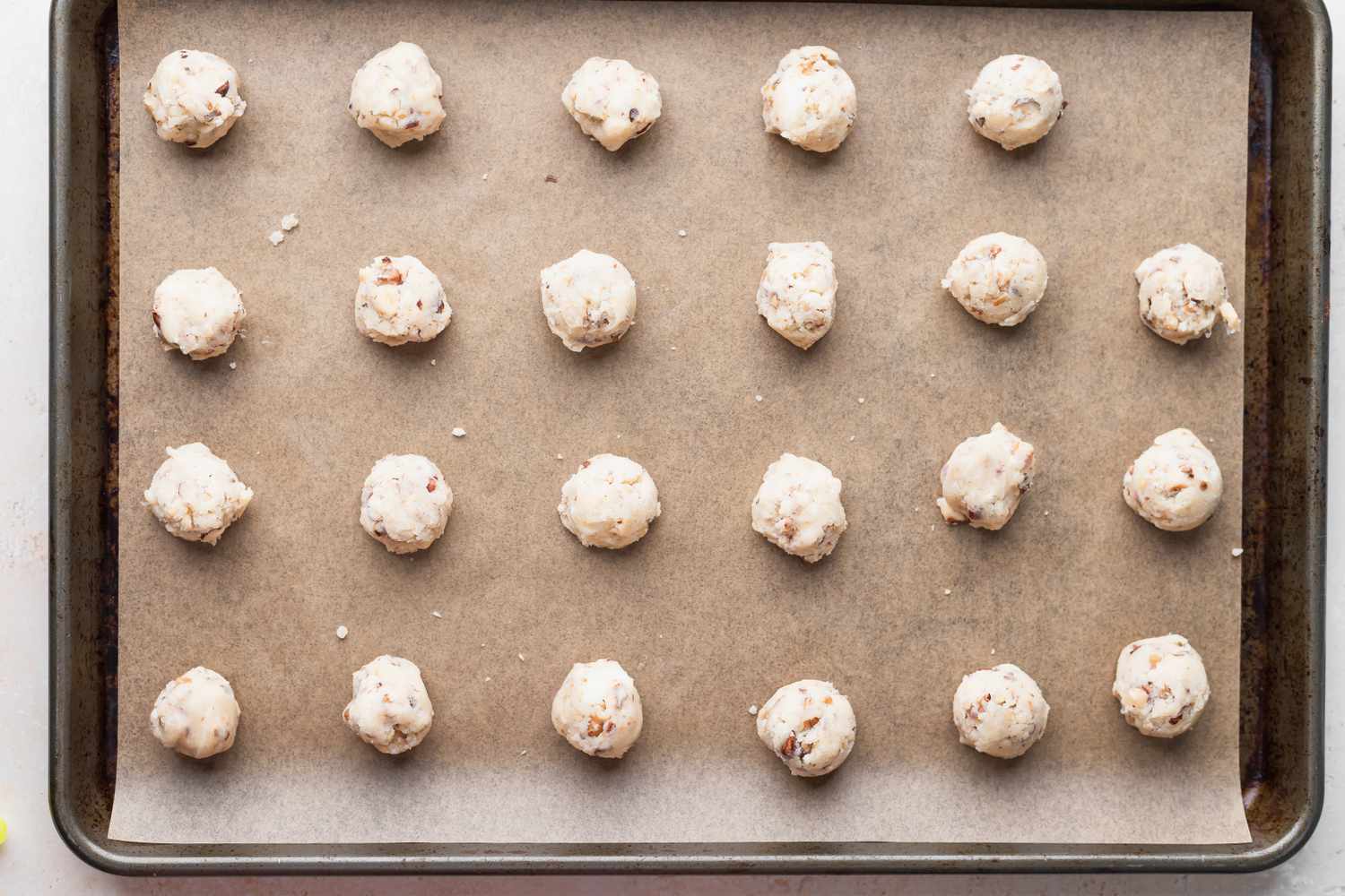 Walnut cookies recipe balls on a baking sheet.