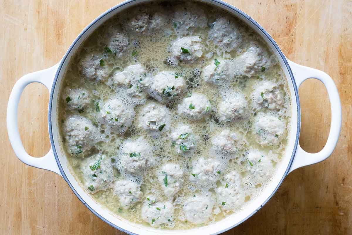 Italian wedding aoup meatballs cooking in a pot.