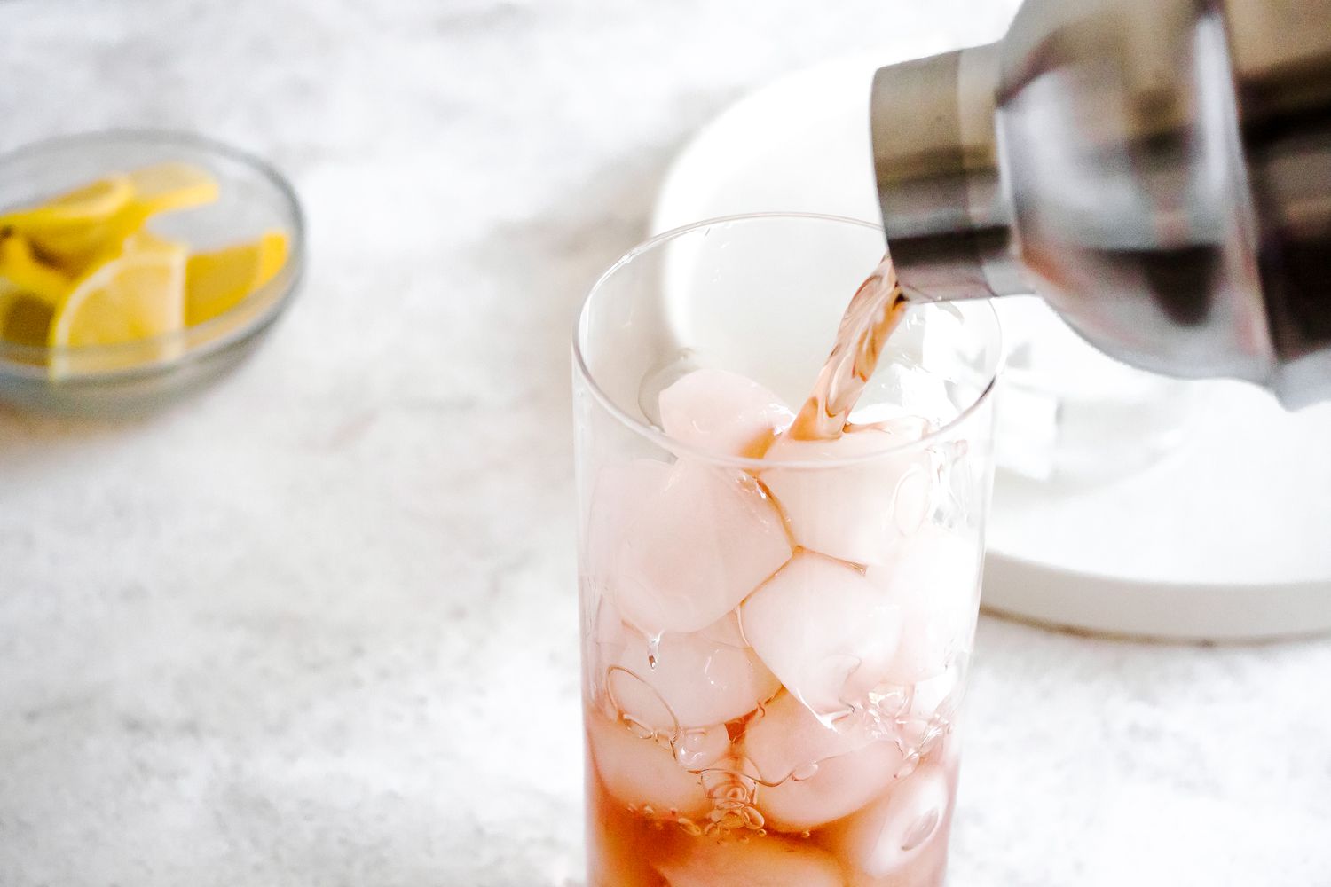 Pouring Out Sloe Gin Fizz From a Shaker into a Glass