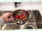 washing strawberries in a colander 