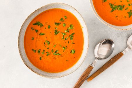 Pumpkin tomato soup garnished with herbs