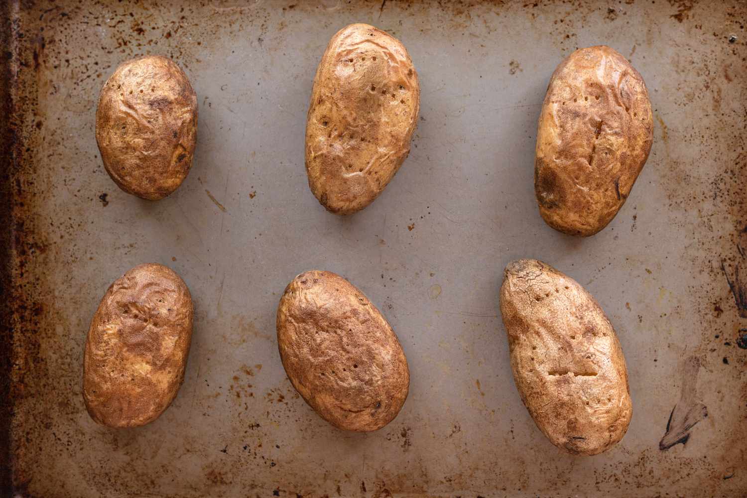 Potatos halved on a baking sheet to make a potato skins recipe.