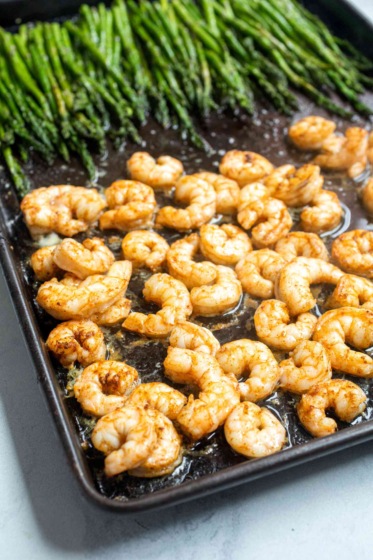 Garlic butter sheet pan shrimp and asparagus on a baking sheet.
