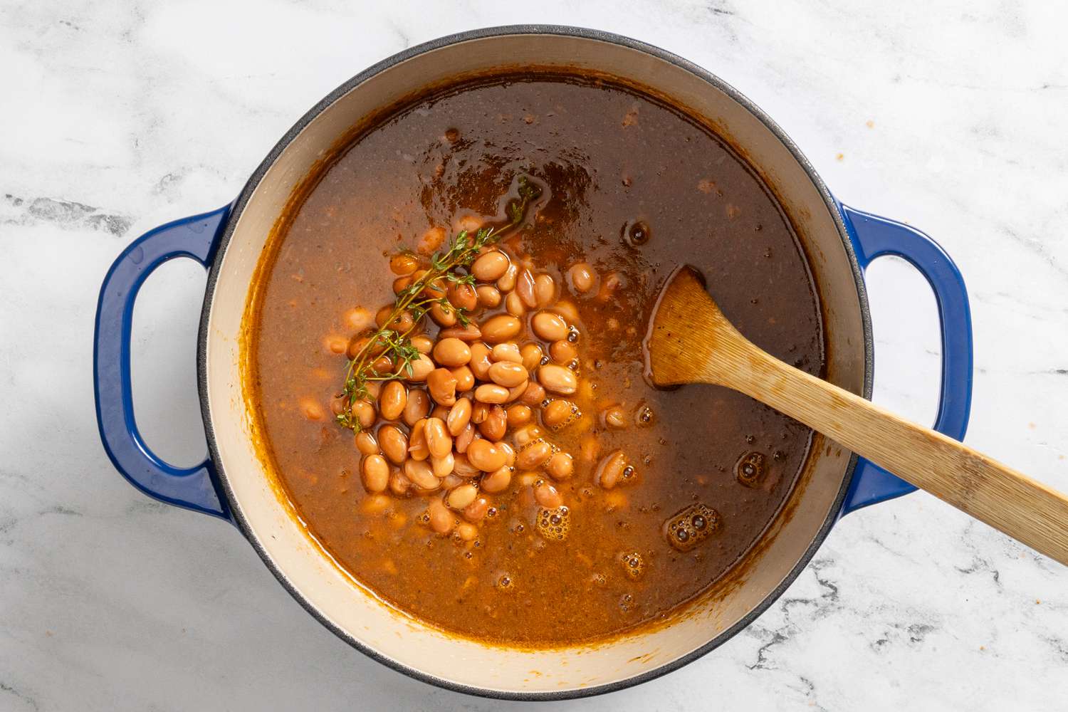 beans and seasoning added to dutch oven for borracho beans (frijoles beans) recipe