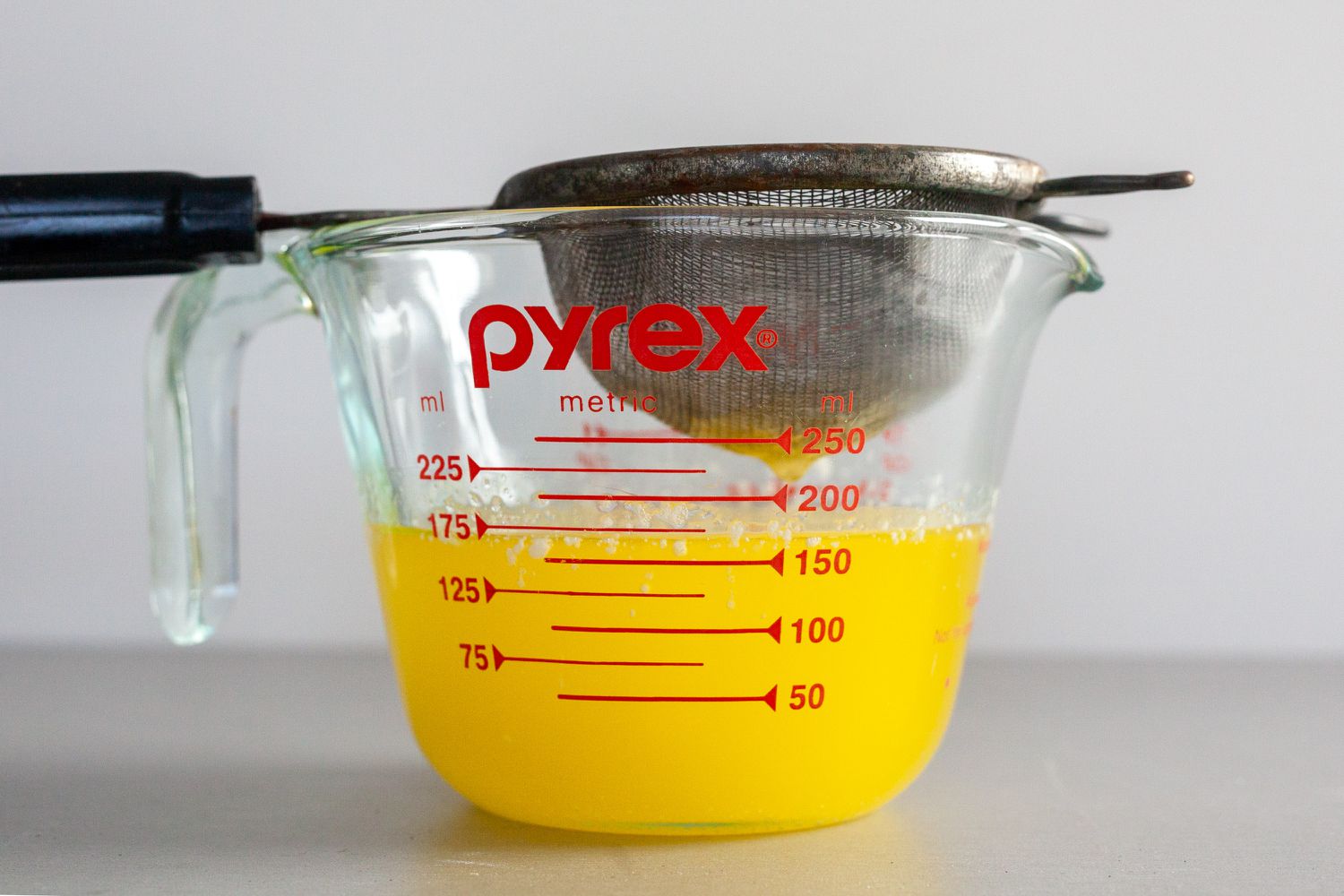 Straining milk solids out of melted butter to make clarified butter for béarnaise sauce.
