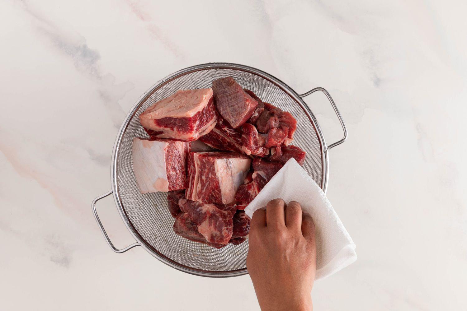 Rinsed beef pieces in a colander and patted down using a paper towel for nilagang baka recipe