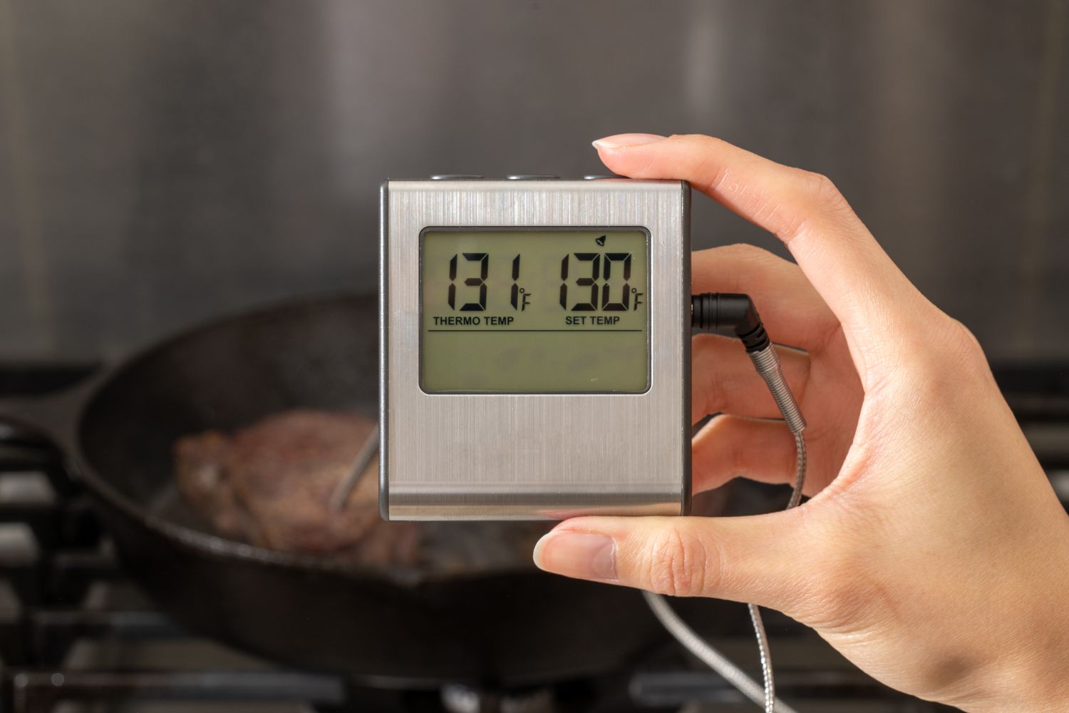 Taking the internal temperature of filet mignon with a thermometer