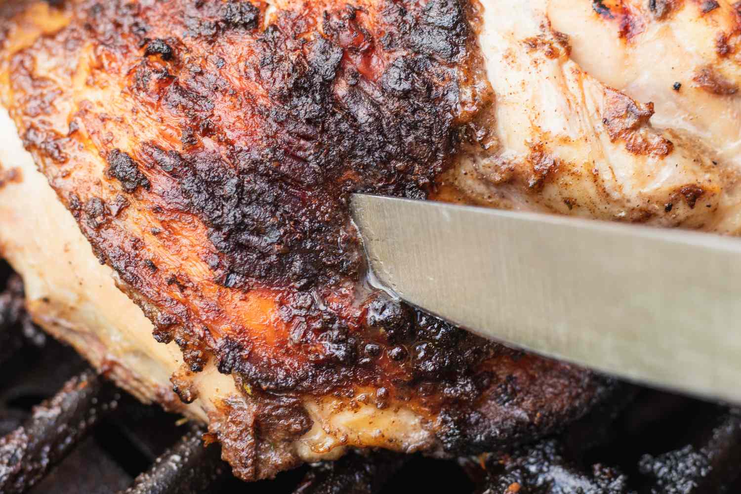 Checking the temperature of grilled chicken to make a jerk chicken recipe.