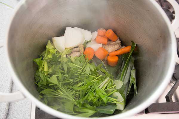 Vegetables on top of chicken pieces for chicken stock