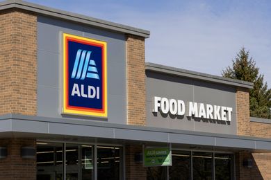 Exterior of an Aldi food market with logo sign and building entrance