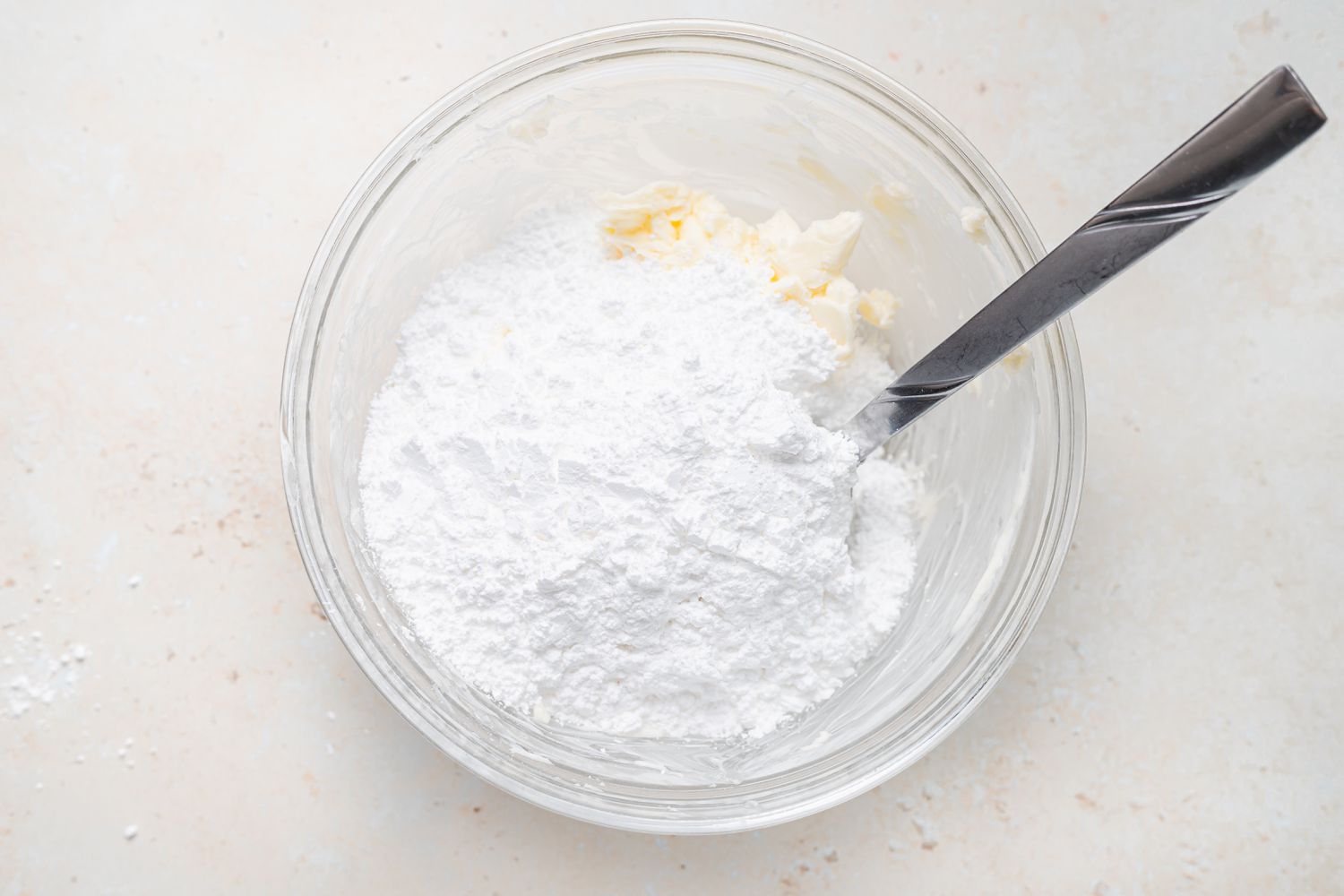 Adding powdered sugar to butter to make buttercream for French macarons filled with lemon buttercream