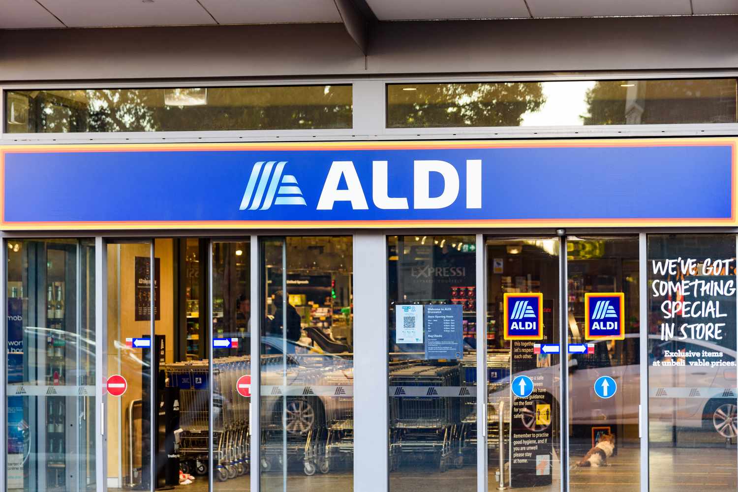 Exterior of an Aldi store entrance with a visible logo and automatic doors
