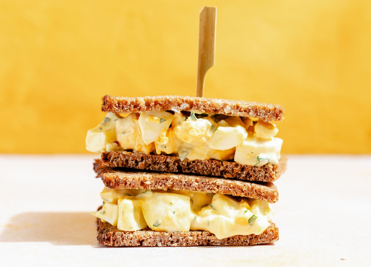 Side view of two stacked egg salad sandwiches