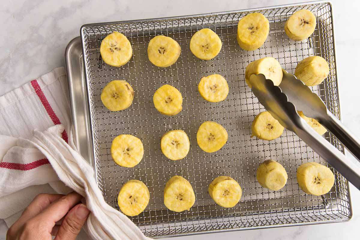 Person flipping sliced plantains in an airfyer basket