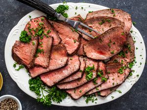 Overhead view of a platter of sliced pan fried steak.