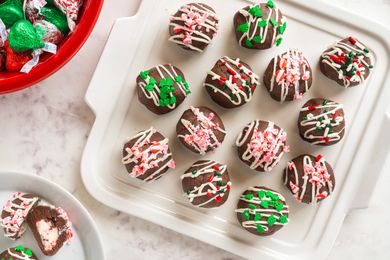 Plate of chocolate bonbons drizzled with frosting and decorated